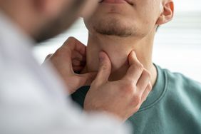 A doctor checking a patient's adam's apple