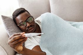 person with AIDS checking for fever