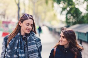 A taller woman and a shorter woman walking together in Paris