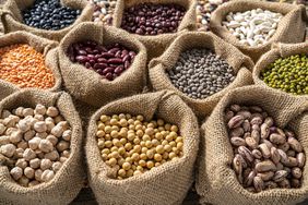 Assorted beans in burlap sacks in a row as a full frame background with chickpeas, lentils, soybean and beans