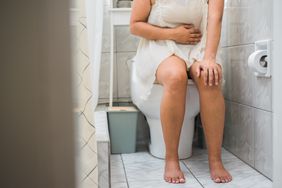 person experiencing bladder infection pain on toilet 