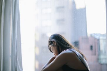 A sad woman looking out the window