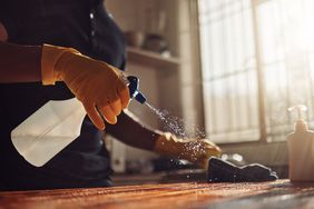 Shot of an unrecognisable man disinfecting a kitchen counter at home