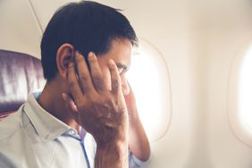 A man with clogged ears in an airplane
