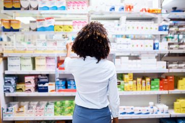 person choosing cold sore medication from a pharmacy
