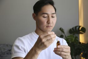 A young man holding a bottle of colloidal silver 