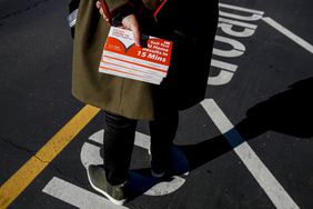 CASTRO VALLEY, CA - DECEMBER 31: The hand of Alameda County Superintendent of Schools, L. K. Monroe, grabs boxes of COVID-19 at-home testing kits while passing them to families before school starts next week at Canyon Middle School in Castro Valley, Calif. on Friday, Dec. 31, 2021. (Brontë Wittpenn/San Francisco Chronicle via Getty Images)