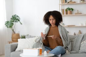 person with a covid variant feeling sick on the couch