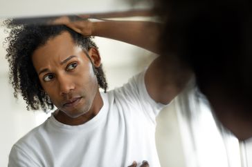 person checking for dandruff in hair