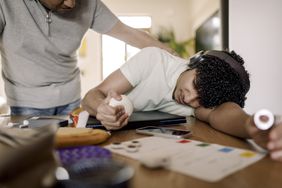 A father looking at his exhausted soon who's having trouble concentrating