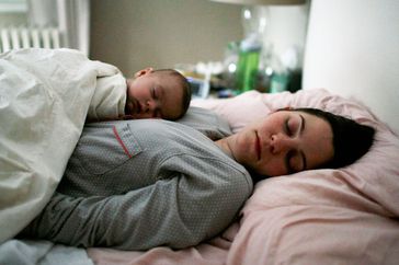 Mother and Newborn Baby Sleeping in Bed