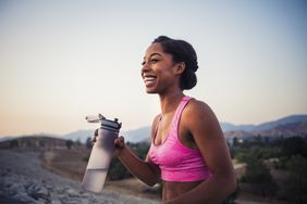 Young black woman is smiling, outdoors, and exercising