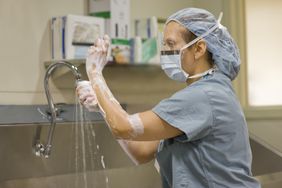 Surgical nurse scrubs her hands