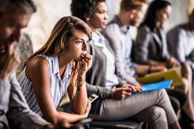 nervous female sitting in group of people