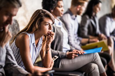 nervous female sitting in group of people