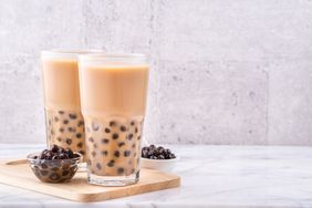 boba tea sitting on wood board on marble white countertop
