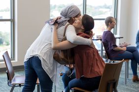 two women hugging at a cancer support group meeting