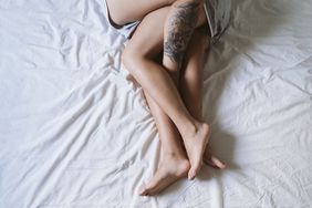 legs intertwined on a bed