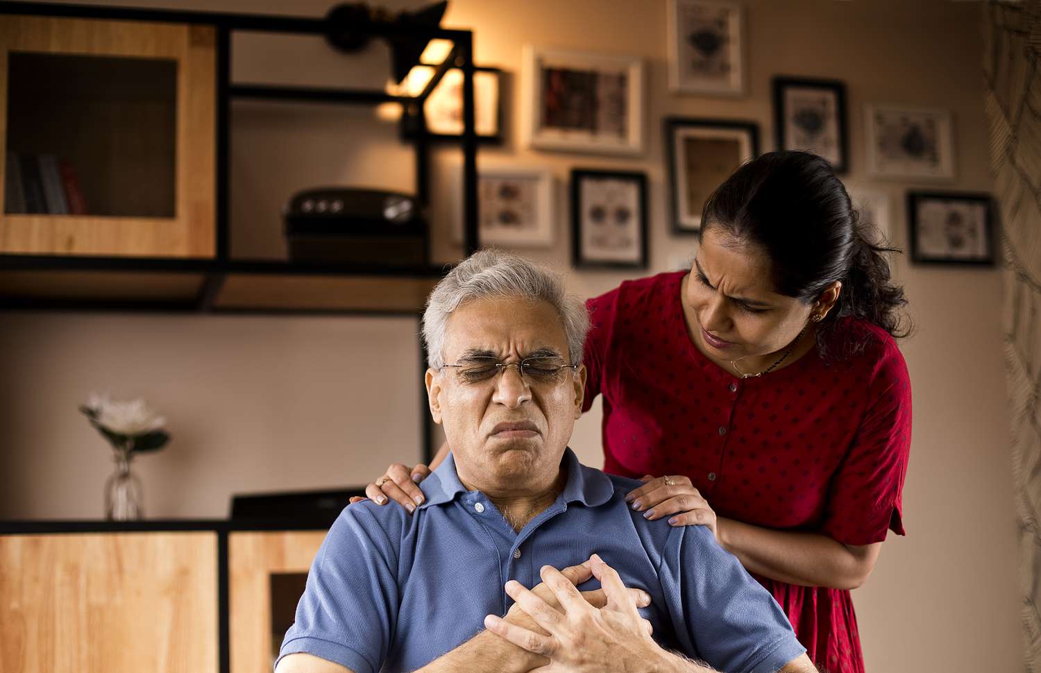 Woman supporting husband with chest pain at home
