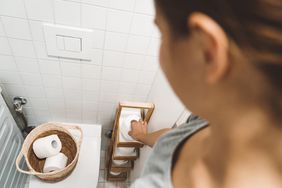 person reaching for toilet paper