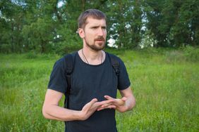 person looking off in to distance in woods