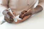 Person taking finger prick blood sample to test blood sugar for hypoglycemia
