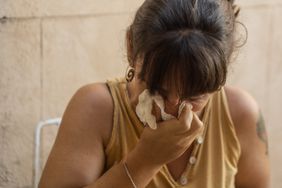Young woman wiping phlegm with tissue