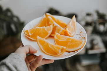 Woman holding a plate or orange peels