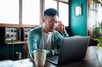 male with hand on head looking sad looking at computer