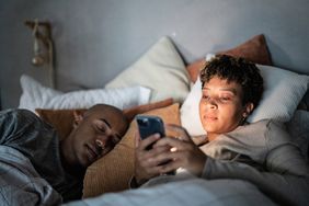 Woman using her phone in bed