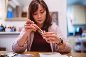 person putting the nasal swab in extraction tube for COVID test at home