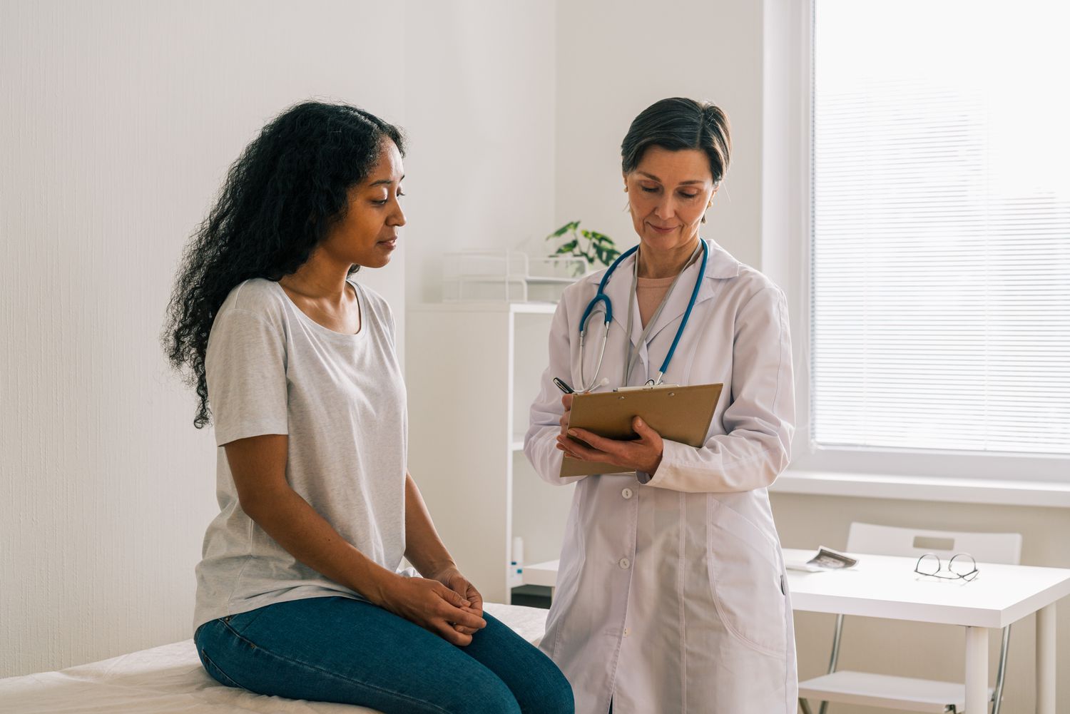 Woman is sharing her symptoms with doctor in doctor's office. 