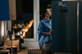 Woman looking in the fridge at night