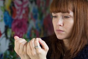 woman looking at her nails displeased