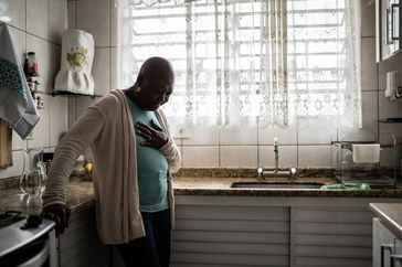 female holding chest in kitchen
