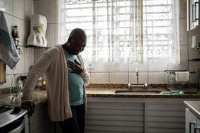 female holding chest in kitchen