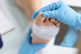Doctor conducts medical examination of foot a covered wound