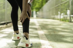a woman massaging her calf due to pain