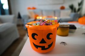 Pumpkin bucket on counter with candy in it