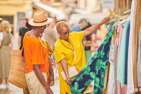 Two people shopping looking at clothing rack