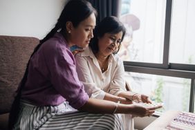 a young woman helping her mother with frontotemporal dementia sort her pills 