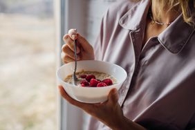 Woman eating breakfast by the window