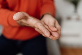 man massaging his hand with tremor