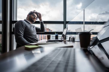 business person staring off into space in office