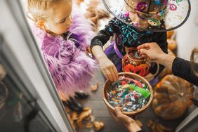 kids trick or treating grabbing candy from bowl