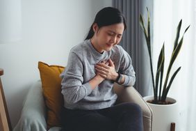 female with hands on chest in pain