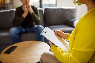 therapist talking to male sitting on couch