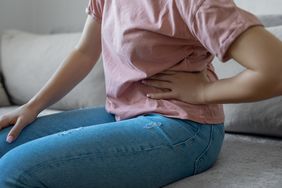 person holding left side of stomach