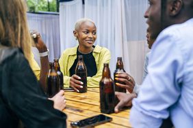 people sititng at table enjoying beers