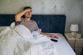 man in bed with headache